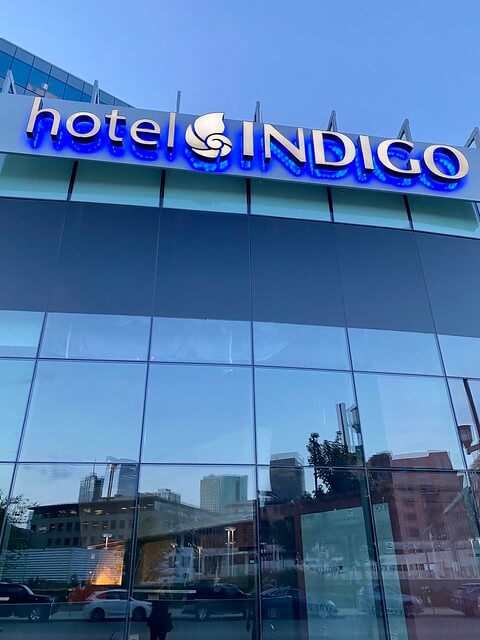 Hotel Indigo logo on the exterior of the glass building.