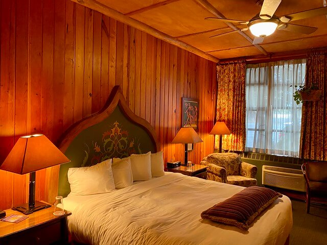King bed with wood paneling in McMenamins Old St. Francis School hotel in Bend, Oregon