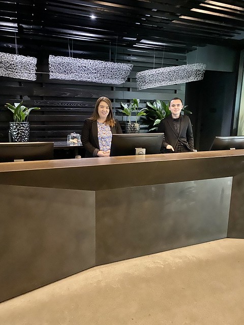 Hotel receptionists, female to left and male to right, ready to check guests into Thompson Seattle hotel. 