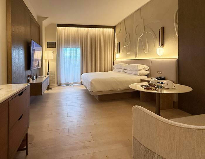 The Bedroom at Tucson Desert Starr Pass features neutral shades of cream with brown wood paneling, light colored tile flooring and indigenous carvings on the wall