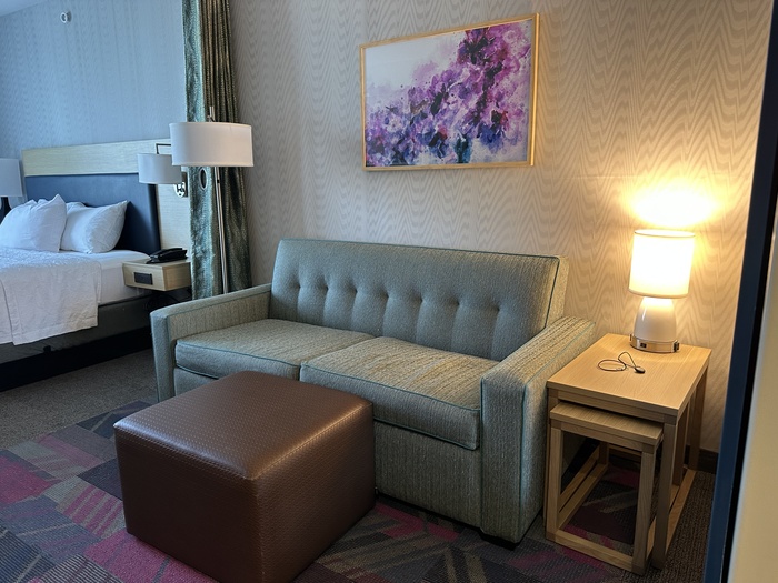 A couch, footrest, end table and lamp.
