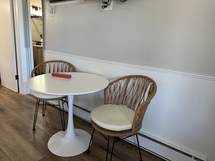 A round table and two chairs in a room at the Fresh Coast Motel.