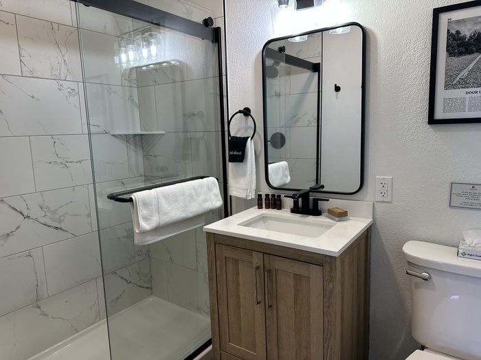 A sink, mirror, and shower at the Fresh Coast Motel.